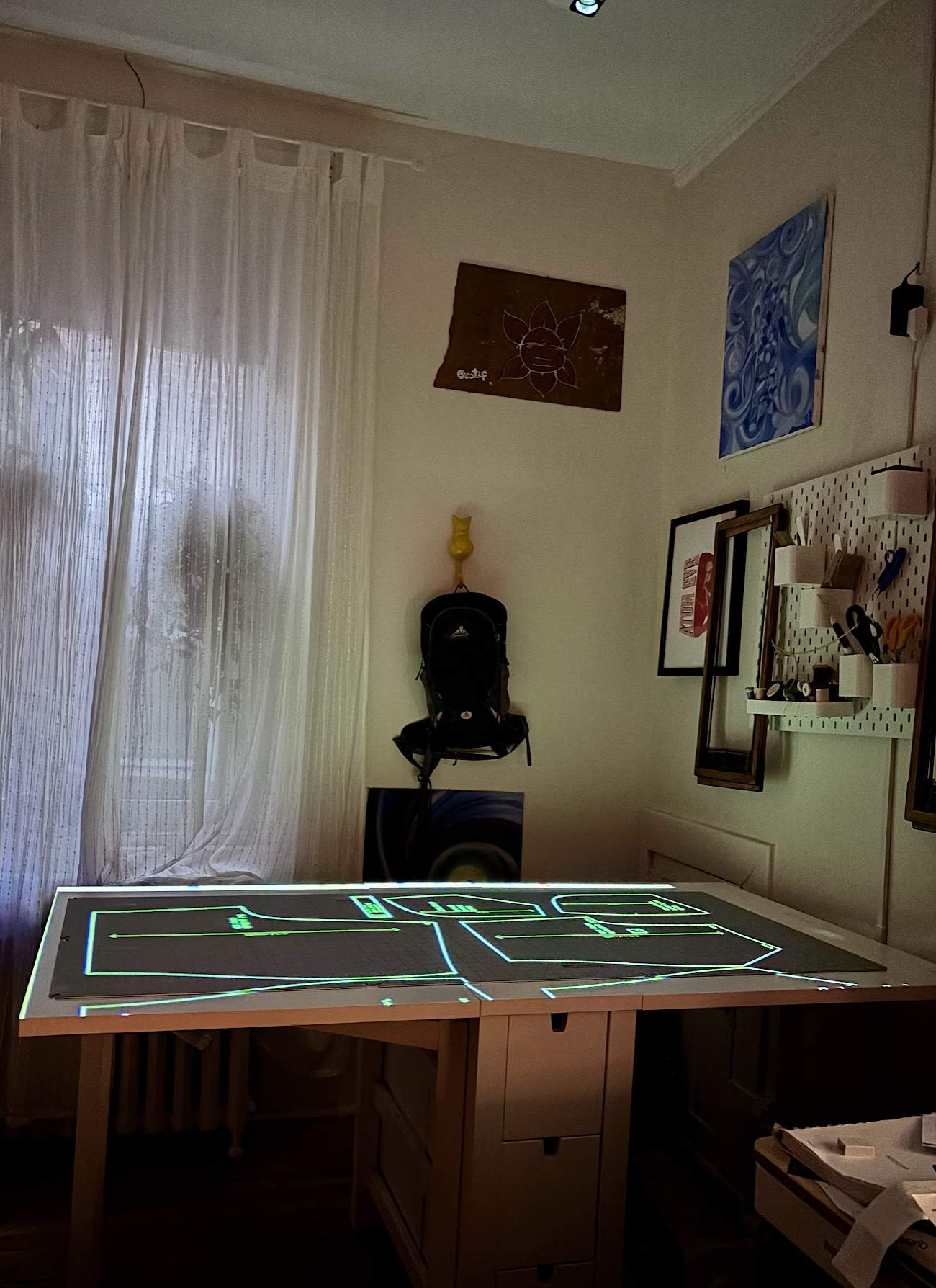 My projector sewing setup, with ceiling mounted projector, casting a pattern onto cutting mats on a table.